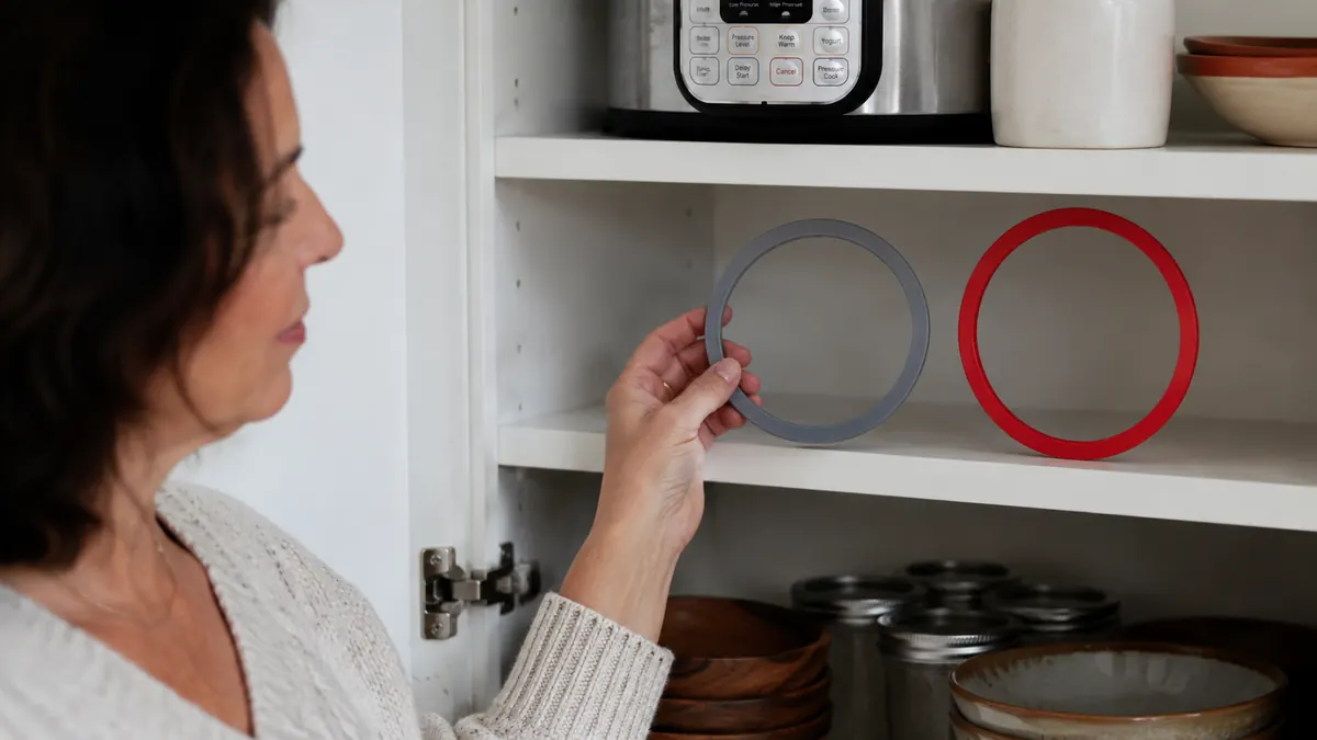 Two Instant Pot sealing rings, one gray and one red, sitting side by side on an open shelf to keep sweet and savory cooking smells separate
